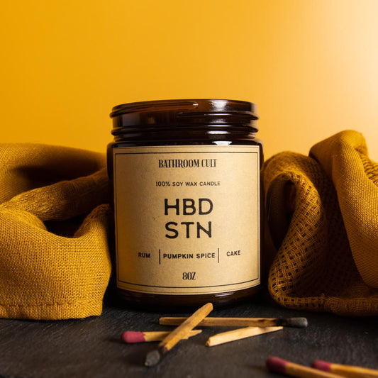 amber glass candle reads hbd stn: rum, pumpkin spice, cake
